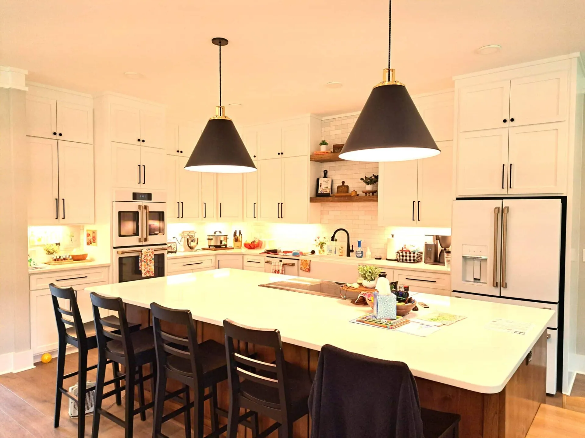 Finished custom-home kitchen with a central island and pendant lights.